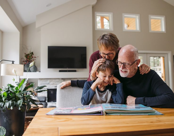 Grandparents and kid looking at photobook together