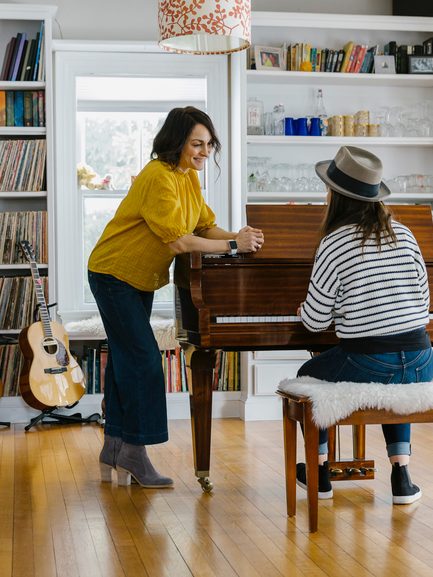 amily with Young teen Girl playing music Piano With her mother watching Her