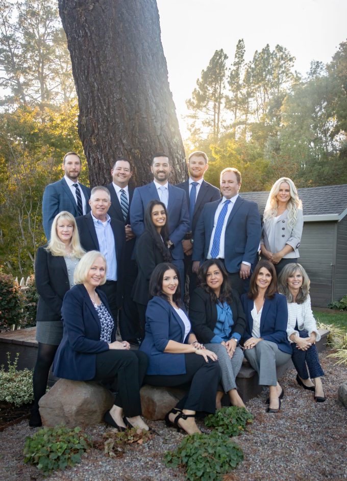 Staff from Capital Advantage pose for a group image sitting in front of a tree