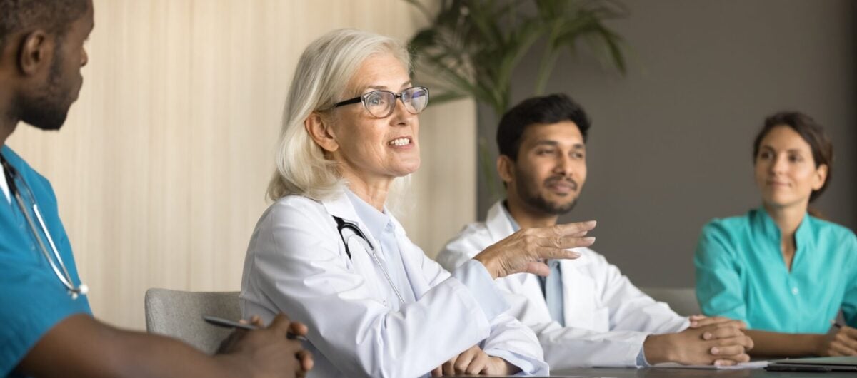 Female doctor sitting and talking to medical team