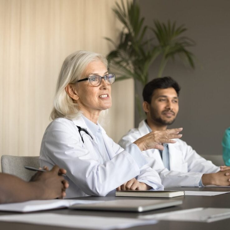 Female doctor sitting and talking to medical team