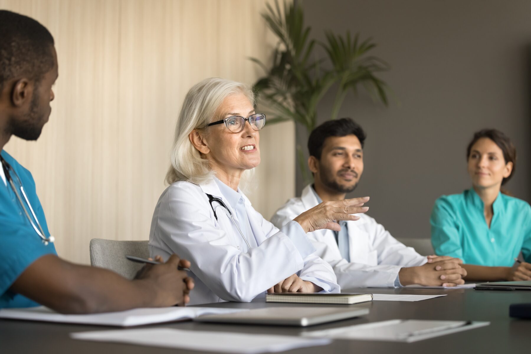 Female doctor sitting and talking to medical team