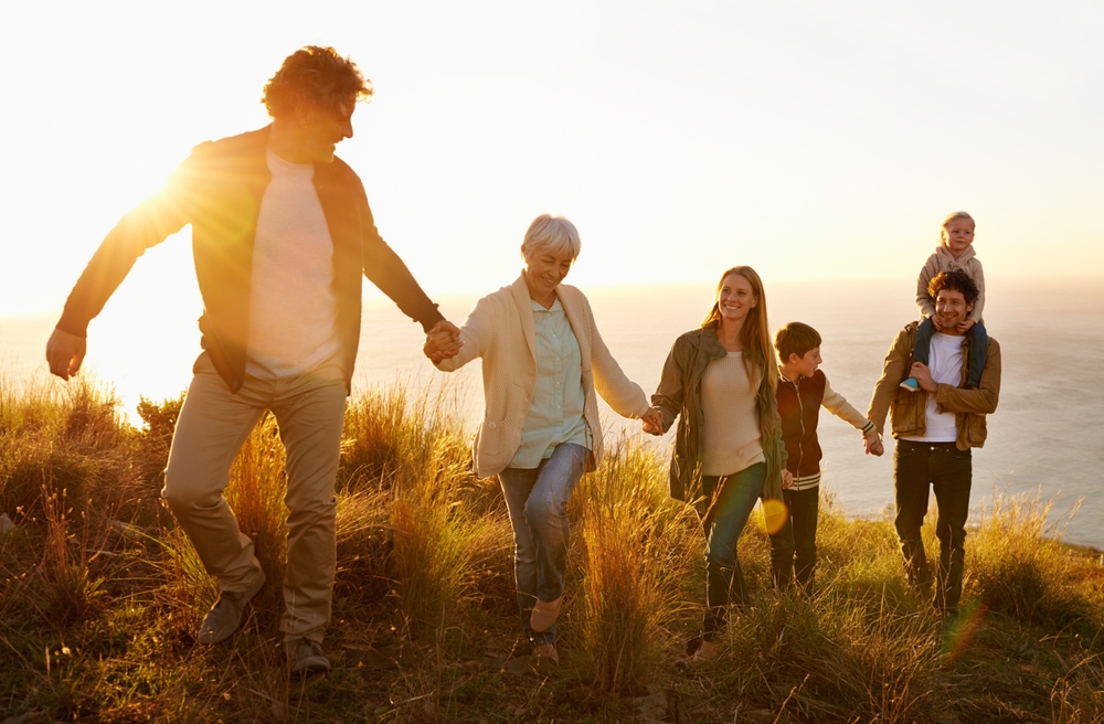 Multi-generational family holding hand walking up hill